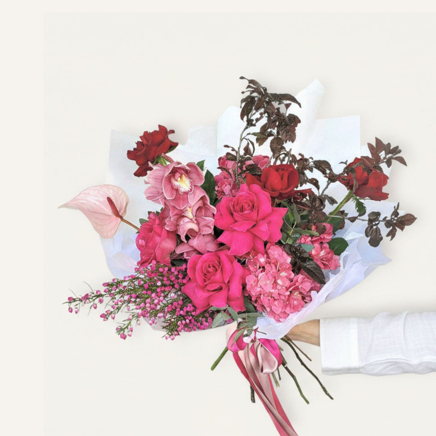 Bouquet of pink and red flowers with a white ribbon on a light background Ormond flower delivery