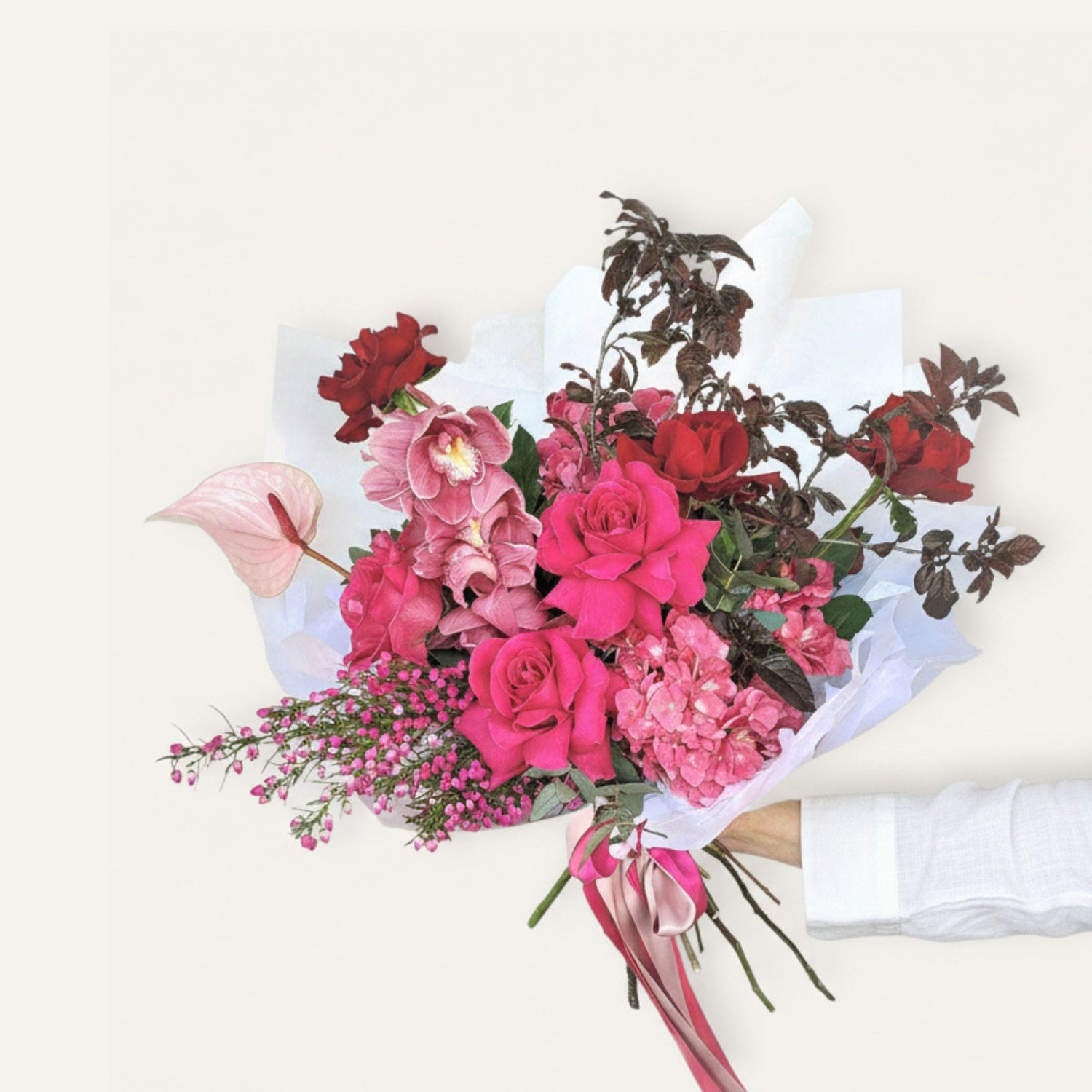 Bouquet of pink and red flowers with a white ribbon on a light background Ormond flower delivery 