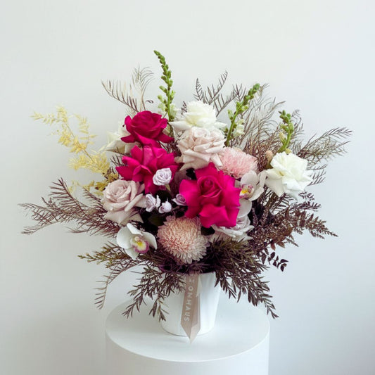 Pink roses and season flowers in ceramic pot on plinth same day delivery Bloomhaus Melbourne