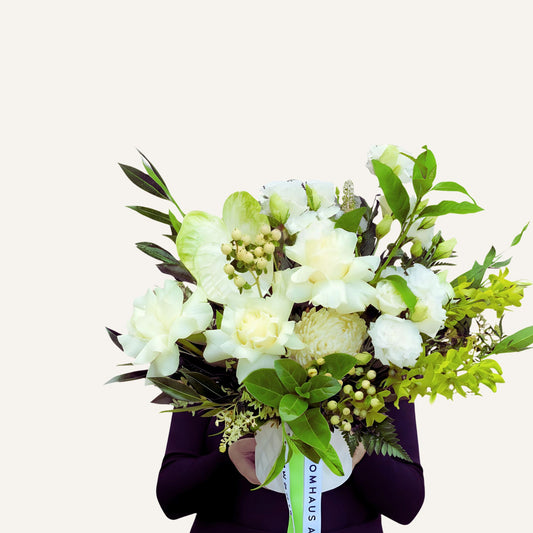 Bouquet of white flowers with green leaves held by a person against a white background Bloomhaus Melbourne McKinnon 