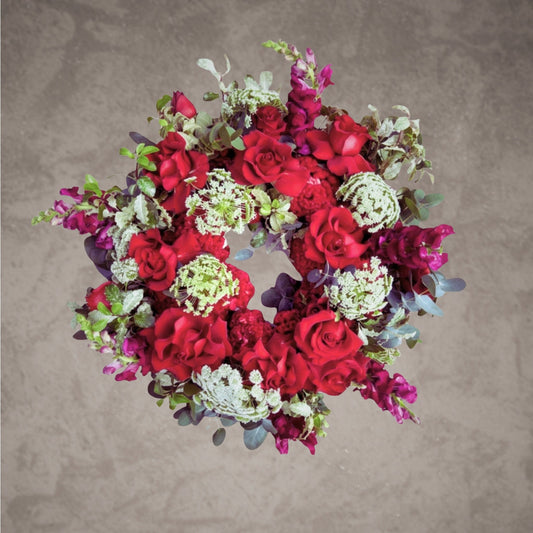 Red funeral wreath with vibrant flowers from Bloomhaus Melbourne titled Eternal Devotion, designed for memorial and funeral tributes.