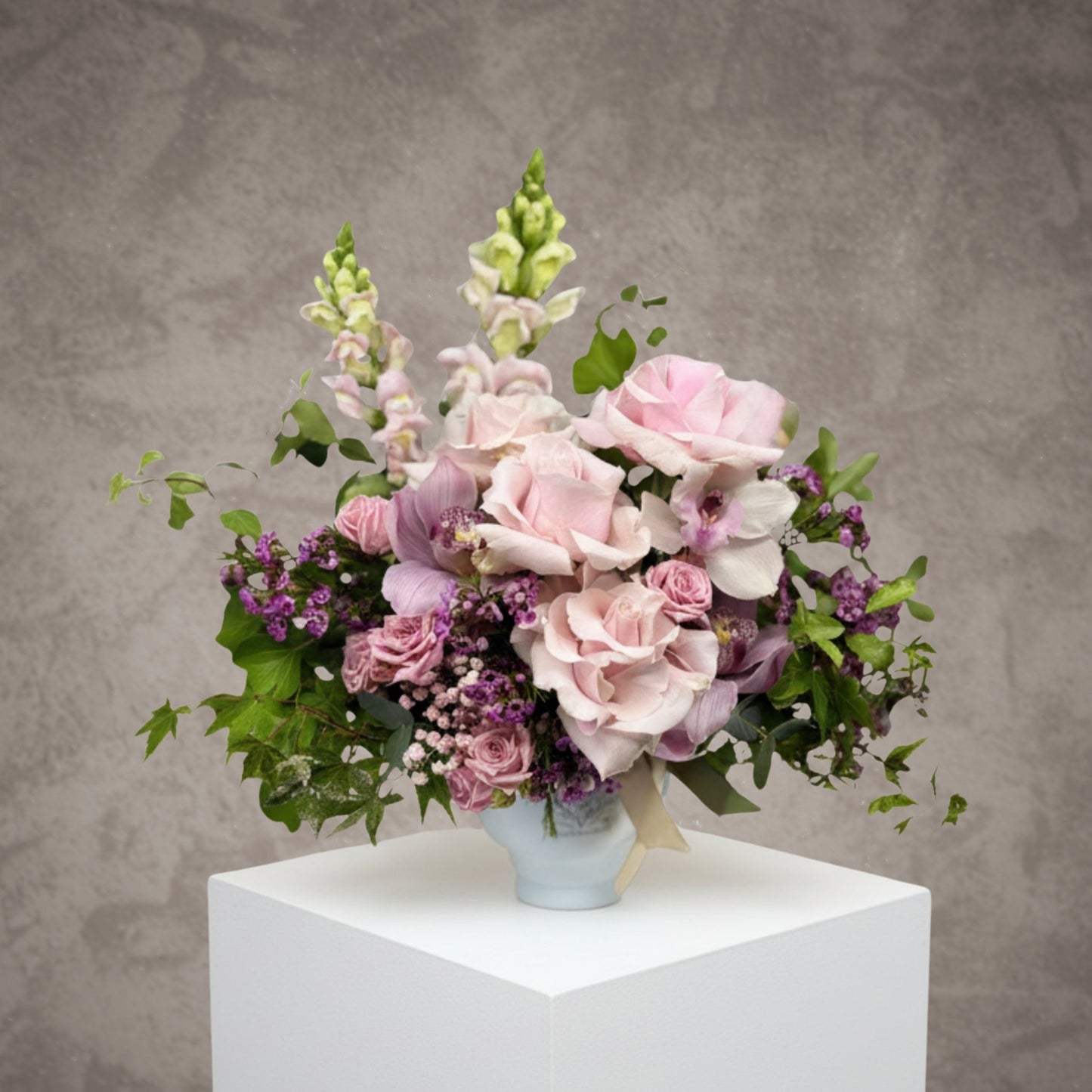 Bouquet of red and pink roses with "Je t’aime" message from BLOOMHAUS MELBOURNE, arranged with lush greenery in a clear vase.