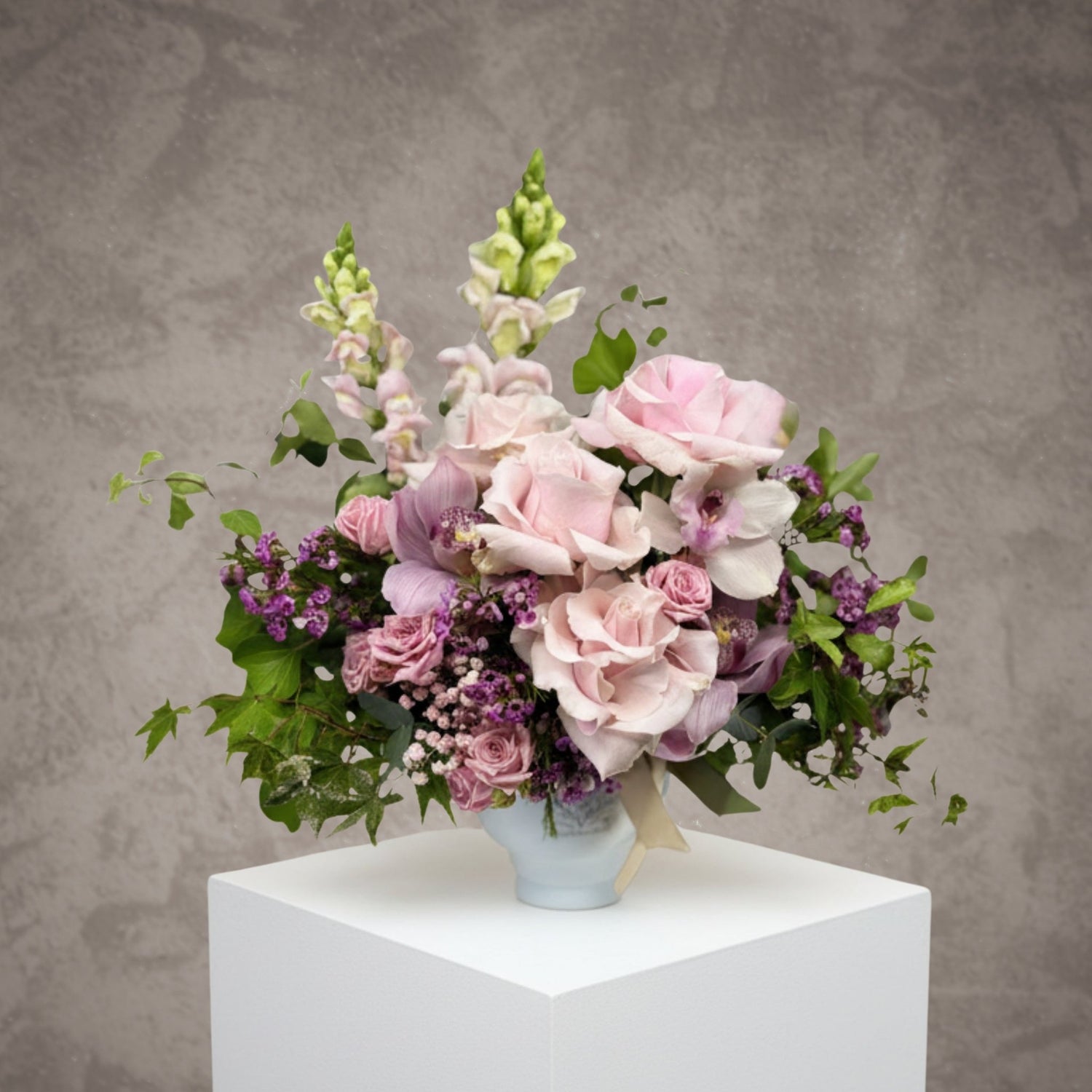 Bouquet of red and pink roses with "Je t’aime" message from BLOOMHAUS MELBOURNE, arranged with lush greenery in a clear vase.
