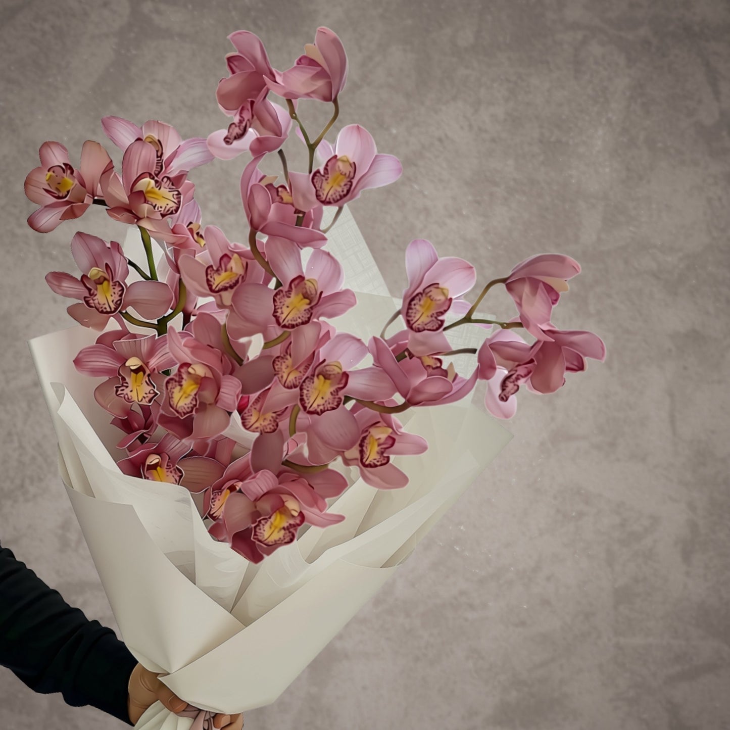 Luxury pink cymbidium orchid bouquet in sculptural white wrapping with silver ribbon by Bloomhaus Melbourne