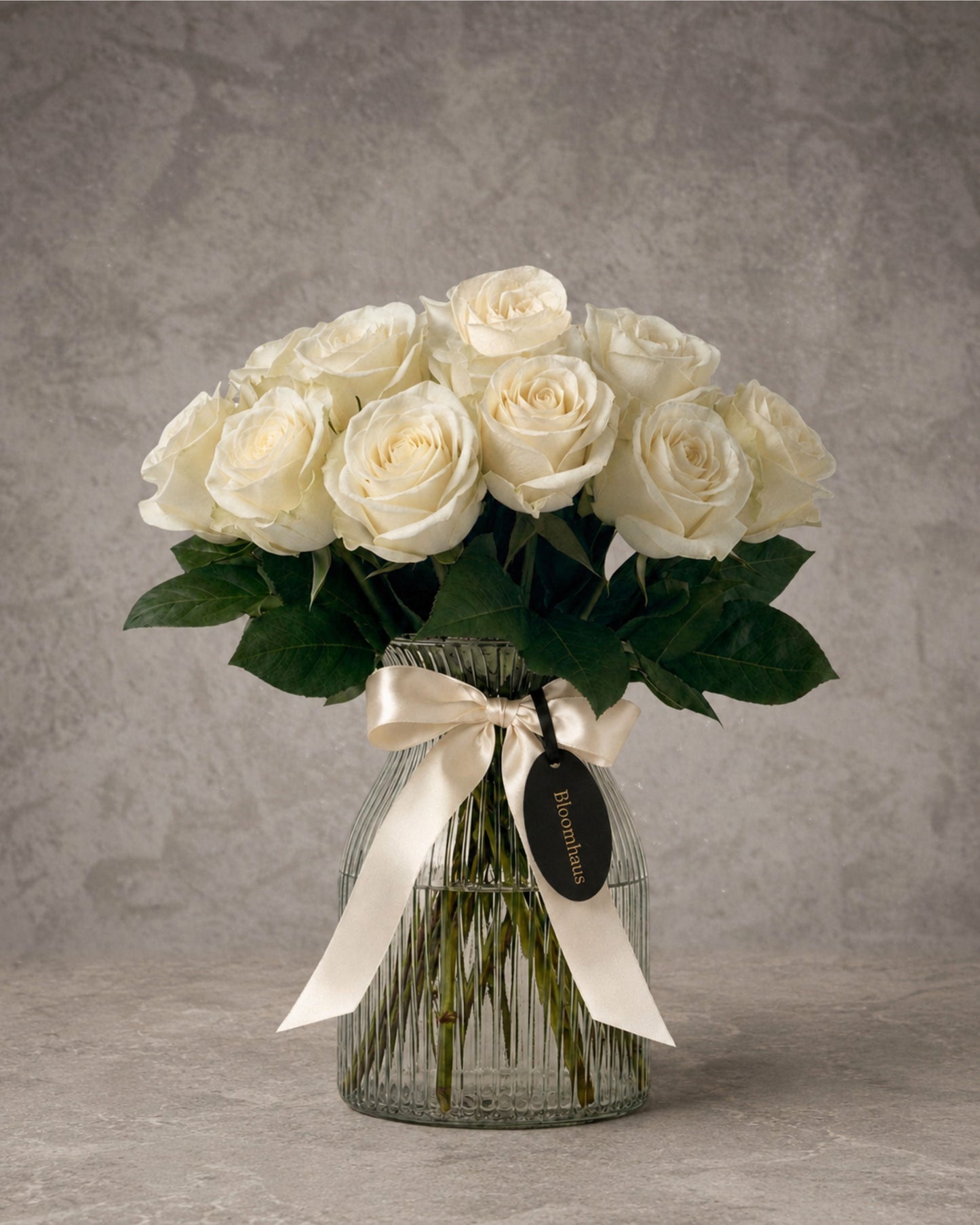 White rose bouquet in a clear glass vase from BLOOMHAUS MELBOURNE, part of the Rose Edit 10 Stem Rose Vase Arrangement.