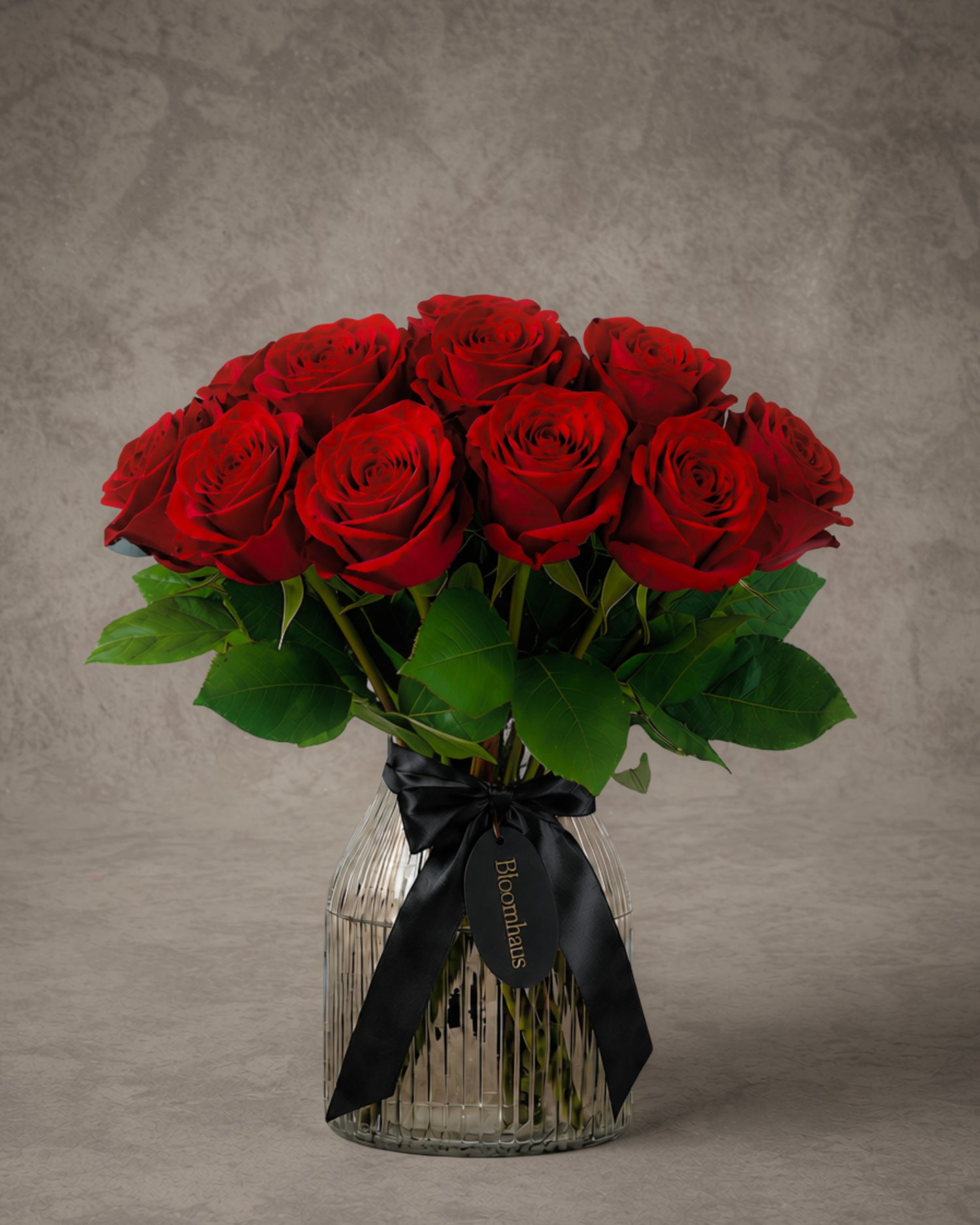 Red rose stems arranged in a glass vase, part of BLOOMHAUS MELBOURNE's Rose Edit floral arrangement.