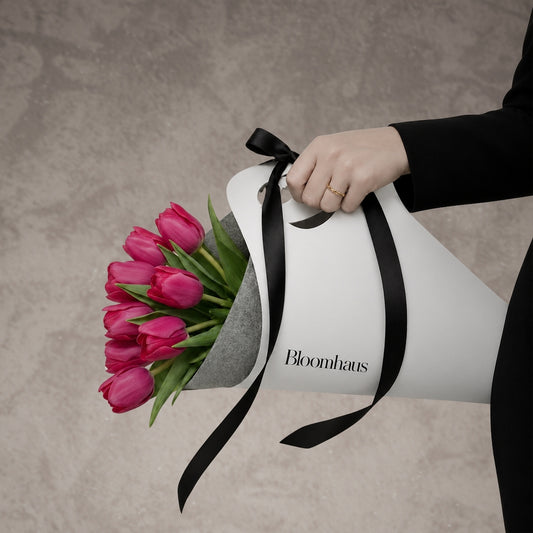Fresh pink tulips arranged in a Bloomhaus Melbourne flower carrier with vibrant leaves and a natural, floral display.