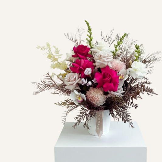 Bright pink rose and seasonal flower arrangement in a pot by BLOOMHAUS MELBOURNE, showcasing vibrant floral beauty.
