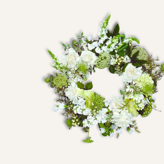 White funeral sympathy wreath with delicate blooms, arranged as a tranquil floral tribute by Bloomhaus Melbourne.