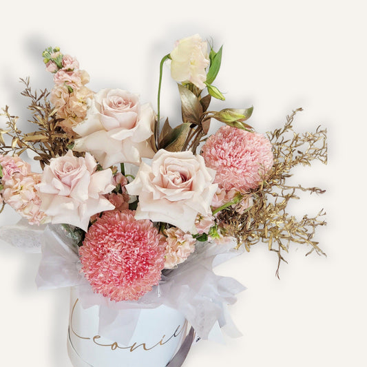 Gola bouquet with radiant roses, disbuds, and seasonal flowers in a personalized hatbox by Bloomhaus Melbourne.