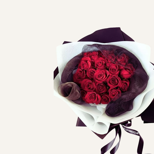 Bouquet of red roses wrapped in black paper with a white ribbon on a light gray background Bloomhaus Melbourne 