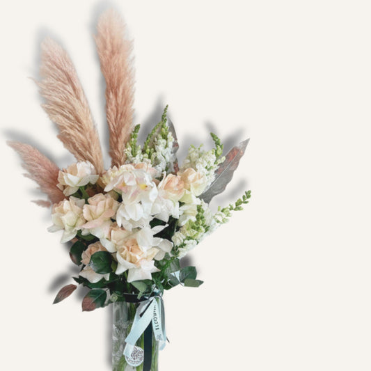 Queen floral arrangement featuring reflexed roses, orchid, seasonal blooms, and pampas grass in a clear glass vase.