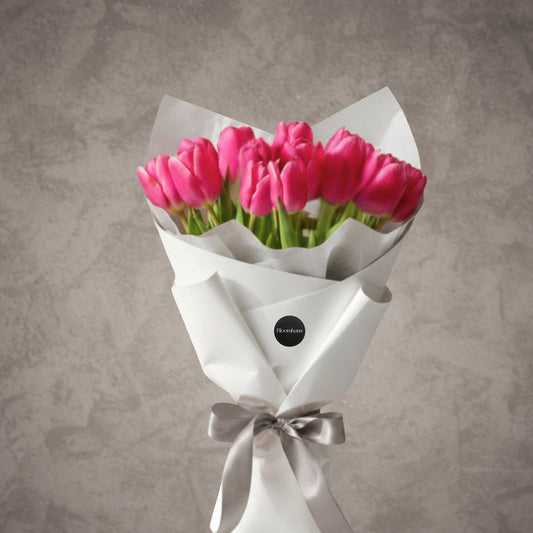 Fresh pink tulips wrapped in paper, showcasing a vibrant bouquet of blooms from BLOOMHAUS MELBOURNE.