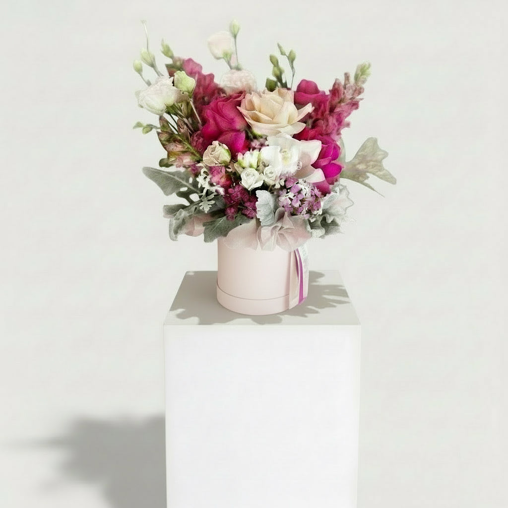 Pink reflexed roses and seasonal blooms arranged in a decorative hatbox, featured in a Bloomhaus Melbourne floral arrangement.