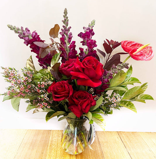 Red rose vase arrangement with reflexed roses by BLOOMHAUS MELBOURNE, showcasing vibrant floral display in a clear glass vase.